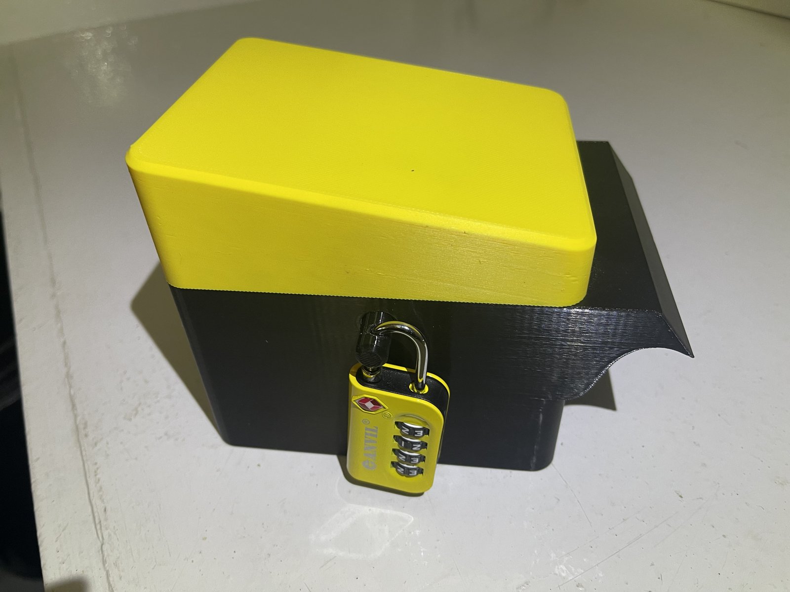 Safety Illuminator tamper proof top, yellow lid locked to the black base with a combination padlock