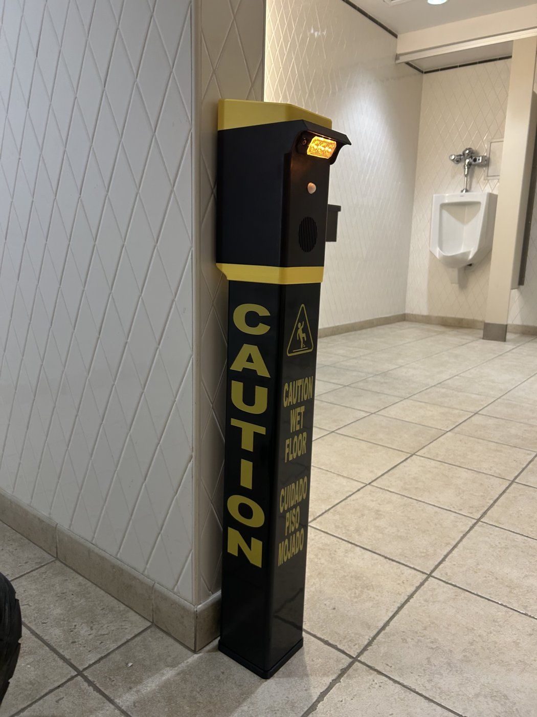 Safety Illuminator Wall Mount Model mounted on a restroom wall, yellow light on